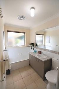 日落大道Sunderland Escape的浴室配有盥洗盆、卫生间和浴缸。