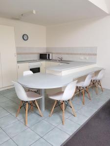 梅林布拉Bayview Apartments的厨房配有白色的桌椅