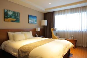 平昌龙平度假酒店的一间设有大床和窗户的酒店客房