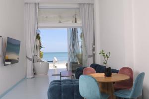 恰洛克拉姆Adika - The beachfront Loft的一间带桌椅和海洋的客厅