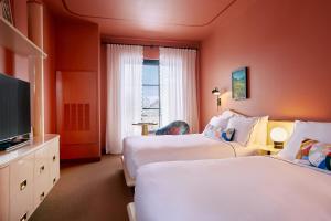 路易斯威尔Hotel Genevieve的酒店客房设有两张床和一台平面电视。