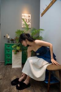 芽庄Oceanus Oasis Retreat Muong Thanh Vien Trieu的坐在椅子上的穿着衣服的女人
