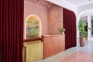 路易斯威尔Hotel Genevieve的审判室,配有红色窗帘和画作的讲台