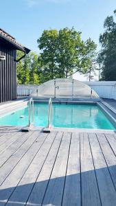 克里斯蒂安桑Brightside Apartment的一座带木甲板的游泳池,位于一座房子旁边