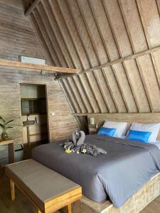 珀尼达岛Kuri Garden Cottage的一间卧室设有一张带木制天花板的大床
