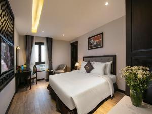 河内Sen Grand Hotel & Spa managed by Sen Group的卧室配有一张白色大床和电视。
