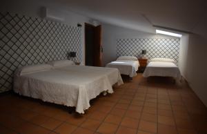 瓜达卢佩阿尔塔米拉瓜达卢佩旅馆的一间卧室设有两张床和窗户。