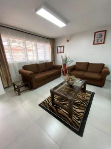 阿鲁沙Imbasa House - Arusha的客厅配有两张沙发和一张咖啡桌