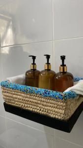 阿鲁沙Imbasa House - Arusha的架子上柳条篮子里的三瓶肥皂