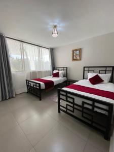 阿鲁沙Imbasa House - Arusha的一间卧室设有两张床和窗户。