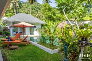 苏梅岛Villa Sumalee 3Br Private Pool的一个带椅子和遮阳伞的花园以及一个游泳池