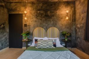 瓦加托Mossy - Aesthetic 2BHK Apartment - Vagator, Goa By StayMonkey的一间卧室配有一张大床和木制床头板