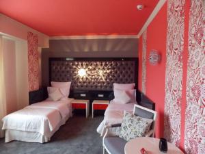 拉姆尼库沃尔恰Simfonia Boutique Hotel的红色客房 - 带两张床和椅子