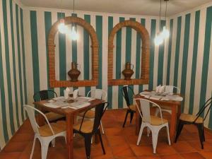 瓜达卢佩阿尔塔米拉瓜达卢佩旅馆的一间用餐室,配有2张桌子和椅子以及2面镜子