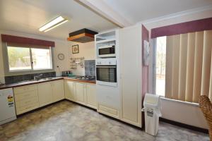 卡尔巴里Aquarius - Kalbarri, WA的一间设有白色家电和窗户的大厨房
