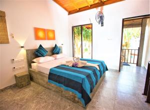 希克杜沃Sea Shell Villa Hikkaduwa 2 Separate Cabanas Ocean Front Villa的一间卧室配有一张带蓝白色床单的大床
