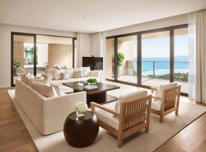 三亚三亚艾迪逊酒店的客厅配有白色家具,享有海景。