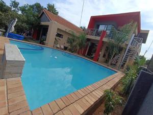 哈博罗内Manasseh Guesthouse的一座大蓝色游泳池,位于房子前