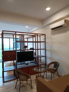 关丹Timurbay Seafront Residence Mawar Inap Homestay的客厅配有电视和桌椅