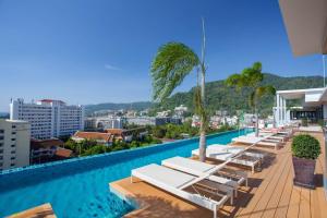 芭东海滩The Marina Phuket Hotel - SHA Extra Plus的酒店游泳池设有躺椅和棕榈树