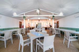 Băltenii de SusAmore Resort的用餐室配有白色的桌子和白色的椅子