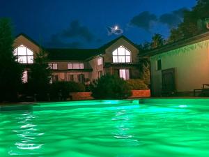 桑日卡Oasis family apartments的夜间在房子前面的游泳池