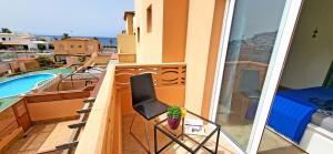 大塔拉哈尔Ferienhaus SUN & OCEAN in Gran Tarajal的一个带椅子和游泳池的阳台