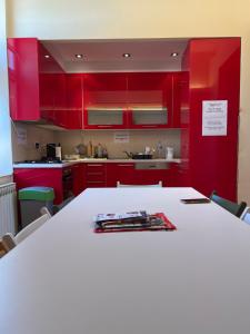 萨拉热窝Joy Apartment的厨房配有红色橱柜和白色桌子