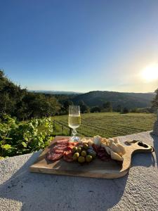 MirnaZerko Holiday Home - Vineyard Chalet With Sauna and Jacuzzi FREE的木板,带食物和一杯葡萄酒