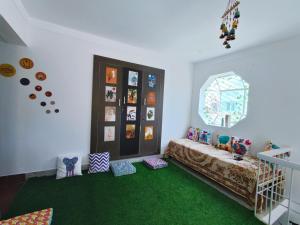 迈索尔Tusker Tribe的客厅铺有绿色地毯,设有窗户。
