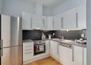 卑尔根Lys & luksuriøs leilighet midt i Bergen sentrum!的厨房配有白色橱柜和不锈钢冰箱