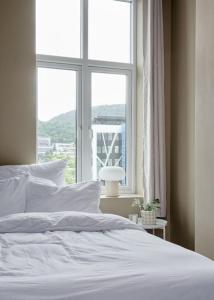 卑尔根Lys & luksuriøs leilighet midt i Bergen sentrum!的卧室配有白色的床和窗户。