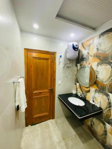 拉合尔Luxury Apartment in Bahria Town, Lahore的一间带水槽和木门的浴室