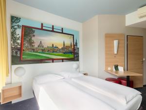 德累斯顿德累斯顿住宿加早餐酒店的卧室配有白色的床和墙上的绘画作品