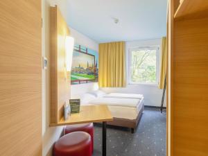 德累斯顿德累斯顿住宿加早餐酒店的酒店客房设有两张床、一张桌子和一个窗户。