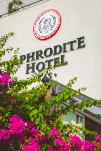 卡斯Aphrodite Hotel Kaş的一座拥有粉红色花卉的磷酸盐酒店标志