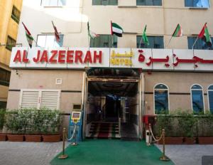 沙迦Al Jazeerah Hotel的前面有标志的建筑