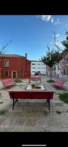 威尼斯Appartement GIUDECCA的坐在庭院里的一群红色长椅