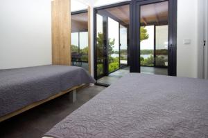 木洛希尼KastHouse Luxury mobile home Anika的一间卧室设有两张床和滑动玻璃门