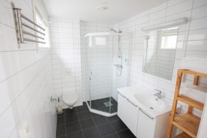Østhusvik布利斯峡湾酒店的带淋浴和盥洗盆的白色浴室