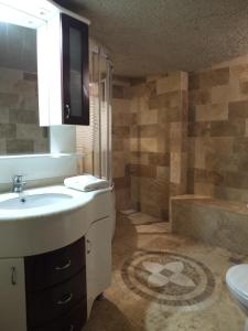 格雷梅Anatolia cave hotel Pension的浴室配有盥洗盆、卫生间和浴缸。