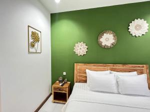 坎古Lubdhaka Canggu的绿色卧室,配有床和绿色的墙壁