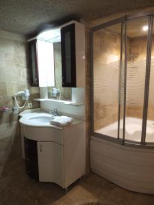格雷梅Anatolia cave hotel Pension的浴室配有水槽、淋浴和浴缸。