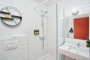 霍芬Höfn - Berjaya Iceland Hotels的带淋浴和盥洗盆的白色浴室