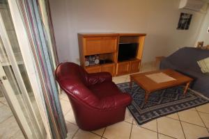 马盖特Rondevoux 29的客厅配有红色皮革椅子和桌子