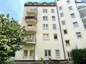 德累斯顿Apartment Uptown im Herzen der Dresdner Neustadt!的一座高大的白色建筑,前面有自行车停放