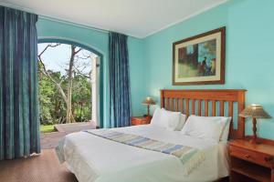 爱德华港Caribbean Estates Holiday Resort的一间卧室设有一张床和一个大窗户