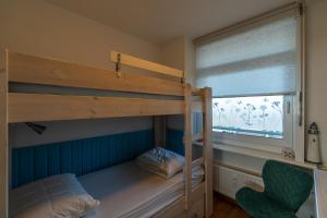 海边的艾格蒙特Appartement Majelle的一间卧室设有两张双层床和一扇窗户。