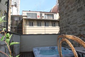 佛罗伦萨Donati Luxury Tower Suites的椅子坐在带热水浴缸的阳台