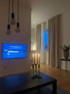 图什比Gröna Huset的客厅配有2把蜡烛和1台平面电视
